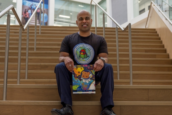 A man seated on a staircase holding a book