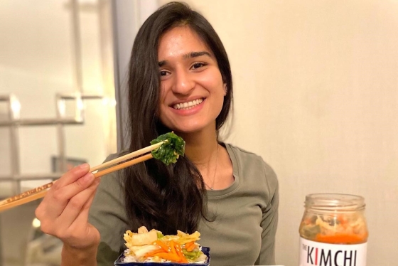 Meraj Ellahi sitting at a table and eating with chopsticks