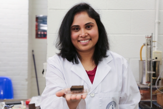 Pavani Cherukupally smiles as she holds out a small square sponge soaked in oil.