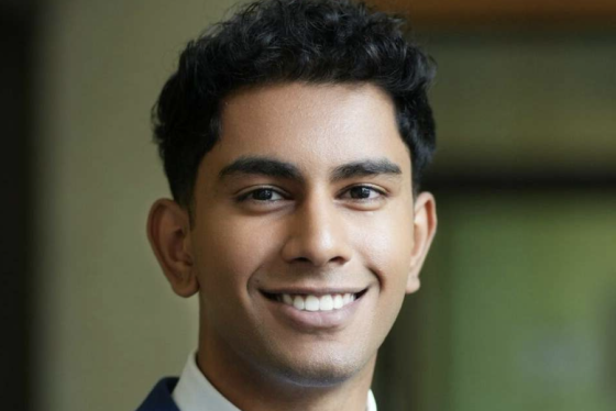 A portrait of Roshawn smiling in a smart blue suit