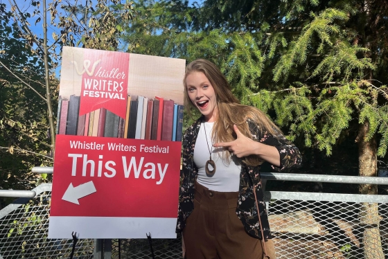 Shannon Terrell pointing to a sign at the Whistler Writer's Festival