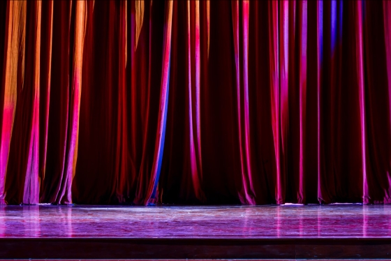 A red curtain pulled across a theatre stage