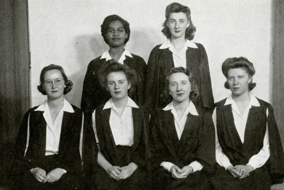 Gloria Carpenter stands in the back row of a formal photo of six women from her 1945 yearbook.