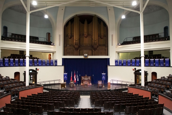 A dramatic view of the Convocation Hall interior: three levels with balconies, huge pipe organ, curving rows of wood seats.