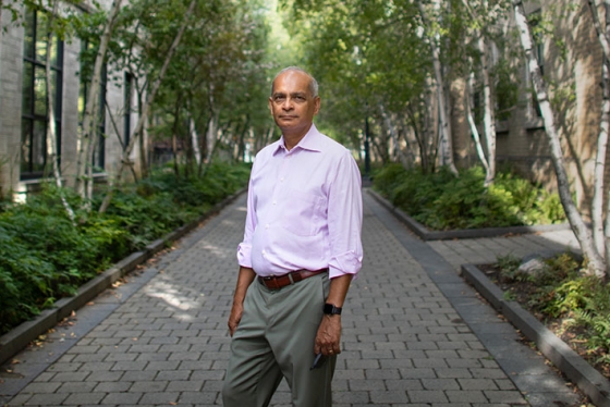 Vivek Goel looks serious as he stands in a leafy alley between buildings on the St. George campus.