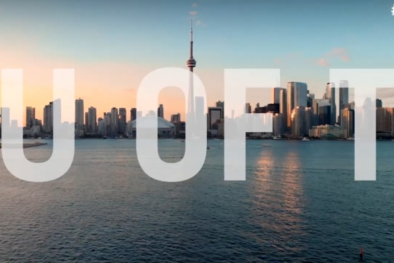 The letters U of T appear superimposed across Toronto's lakefront skyline, with the sun setting.