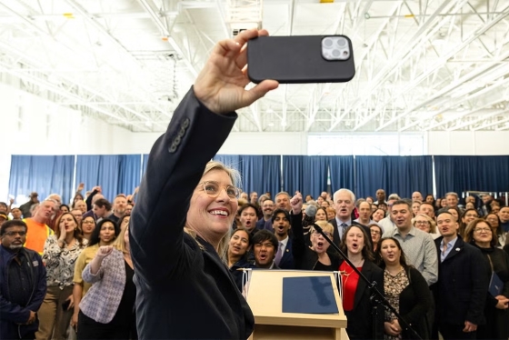 Melanie Woodin taking a selfie in front of an audience