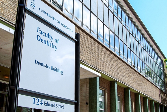 A sign saying University of Toronto Faculty of Dentistry outside a large building on Edward Street.