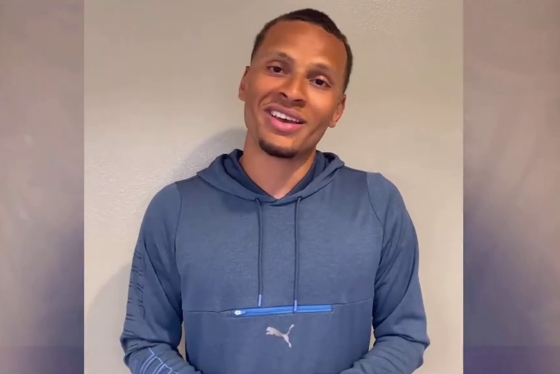 Andre De Grasse smiling and talking on a video call.