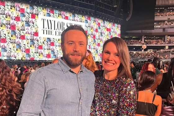 David Lawrence and his wife smiling in front of Taylor Swift's stage