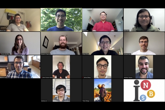 The faces of 14 smiling researchers are seen on a computer screen as they have a video call.