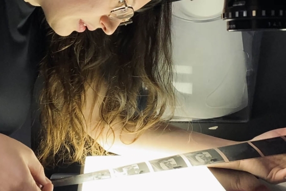 A woman looking at film negatives above a light
