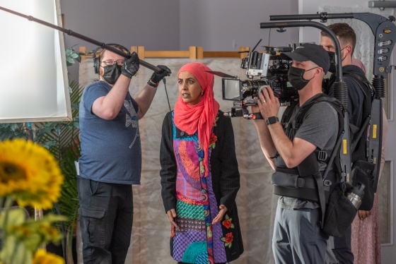 Zarqa Nawaz surrounded by a camera crew