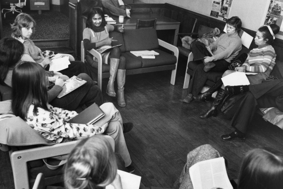 An old photograph from 1975 shows young women gathered in a circle, on comfy chairs, around Ceta Ramkhalawansingh.