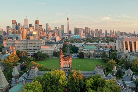 An aerial view of U of T's Front Campus with downtown Toronto behind it, and sunset light washing over the buildings.