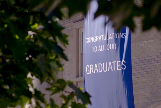 A banner saying Congratulations to all our Graduates hangs outside Convocation Hall.