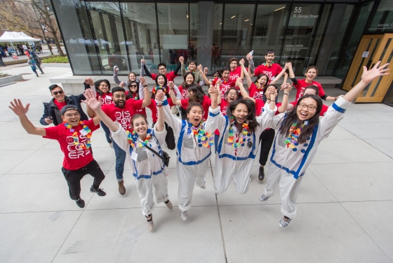 Image shows a group of student volunteers jumping in the air.