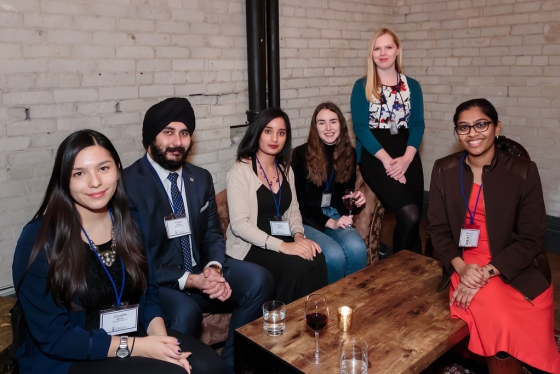 Group of alumni sitting at a lounge table.