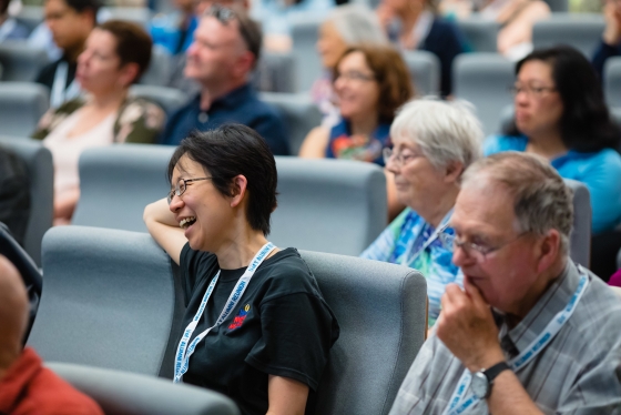 Audience members at lecture laughing at a speaker's joke