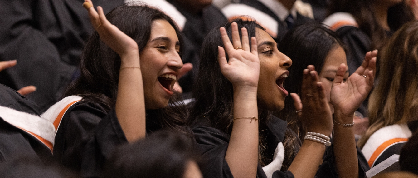 Alumni cheering together at graduation.
