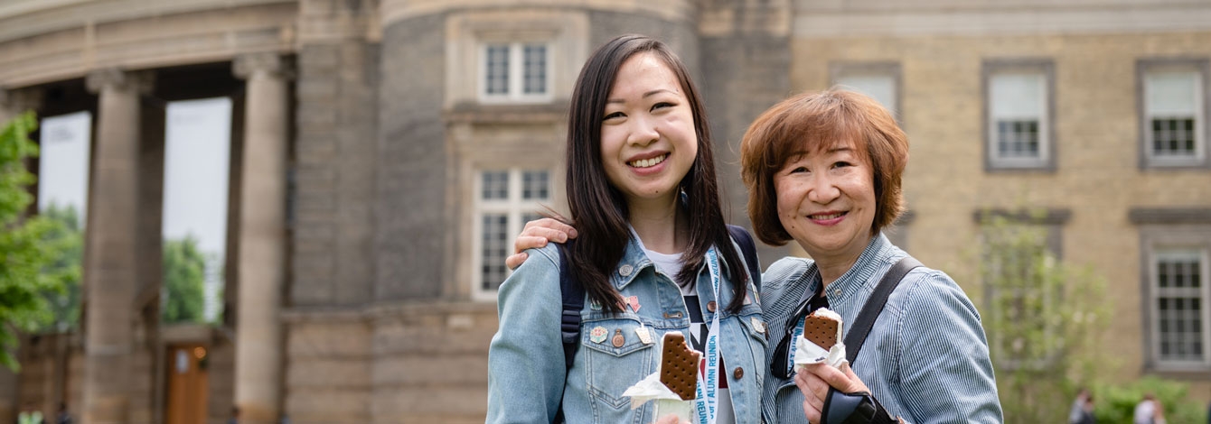 Mother and daughter enjoying ice cream sandwiches in front of Convocation Hall