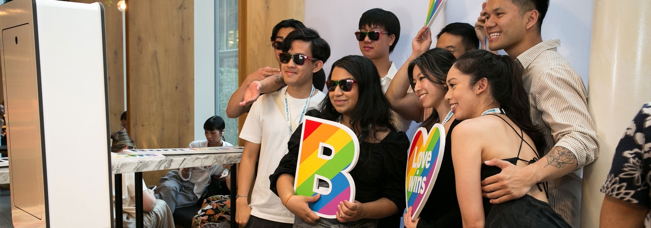 2SLGBTQ+ alumni smiling at photo booth.