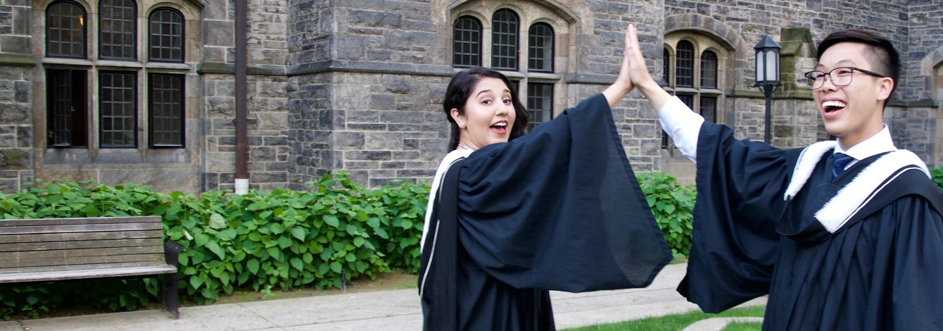 Photo of two new graduates high fiving.