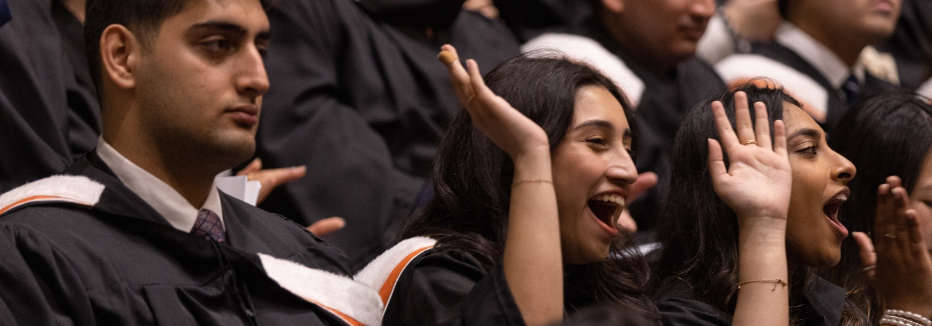 Alumni cheering together in graduation.