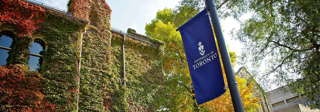 Banner of U of T hanging outside U of T in autumn