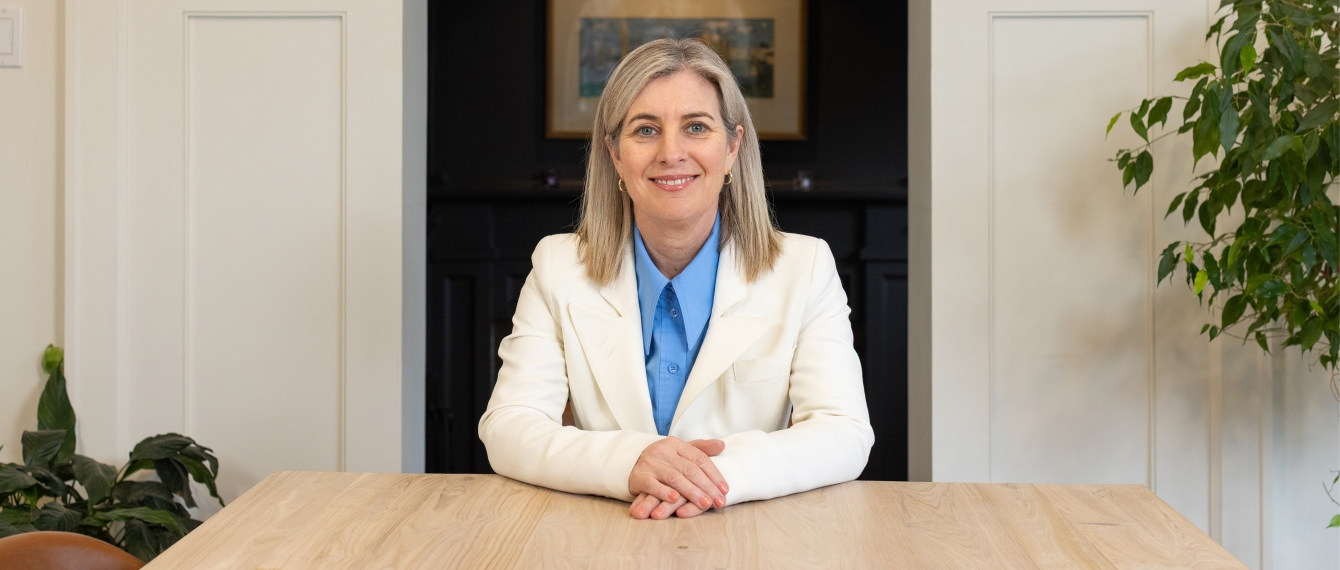 Image of Melanie Woodin smiling in desk.