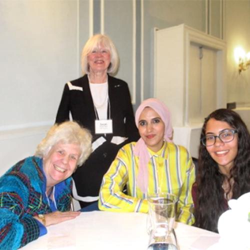 Members of University Women's Club Toronto smiling around a banquet table