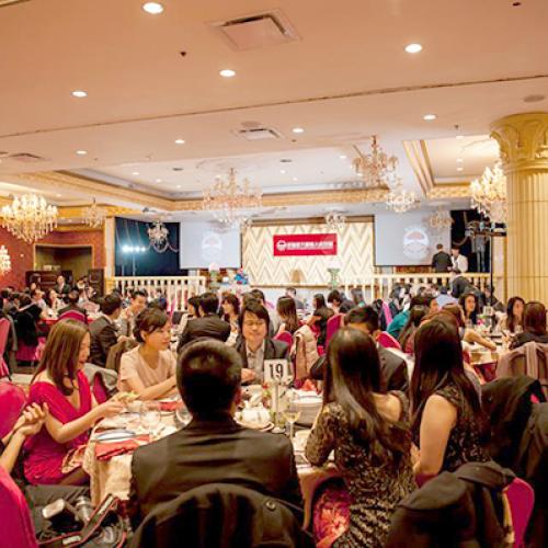 Group of Chinese alumni sit at a banquet table at an elegant dinner event.