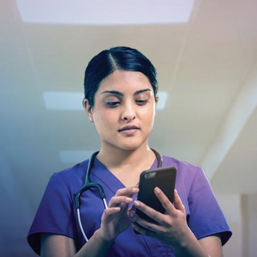 A medical professional uses a smartphone at work