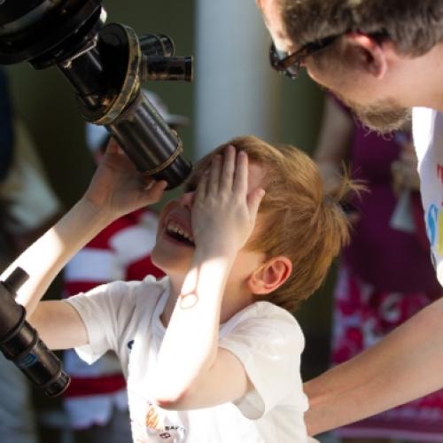 Little kid looking through telescope
