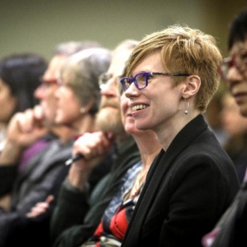 Alumni listening to a lecture smiling