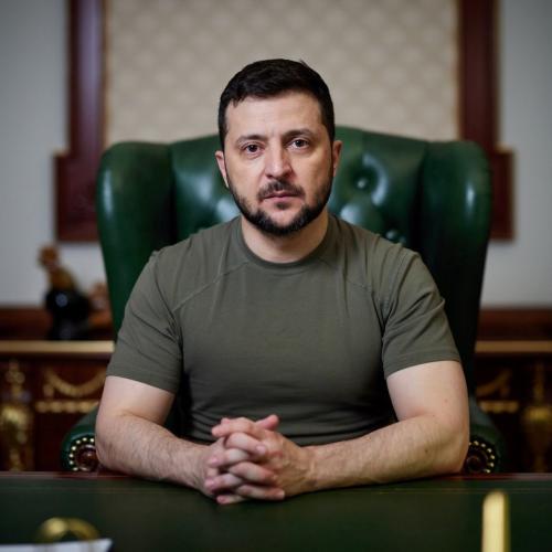 Speaker, President Zelenskyy, white male shown sitting at desk.