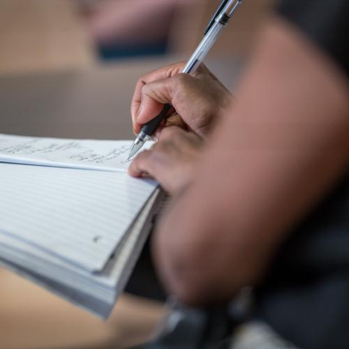 Person writing on notebook