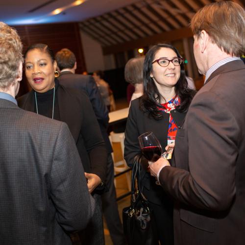 Alumni shaking hands at a networking event.