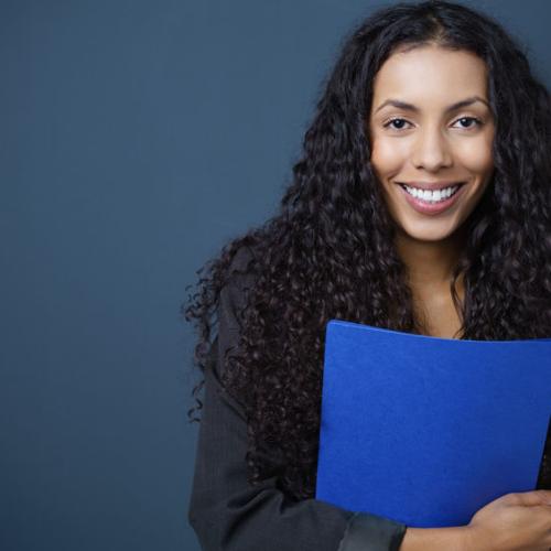 Black woman smiling holding a blue file folder.