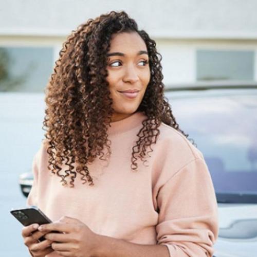 Woman standing in front of her car.