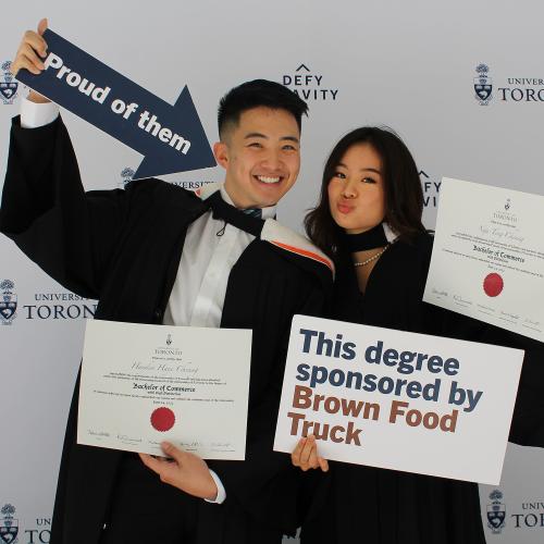 Two alumni smiling together on new grads photo booth.