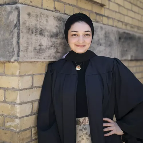 A portrait of Mariam Ismail wearing a black graduation gown