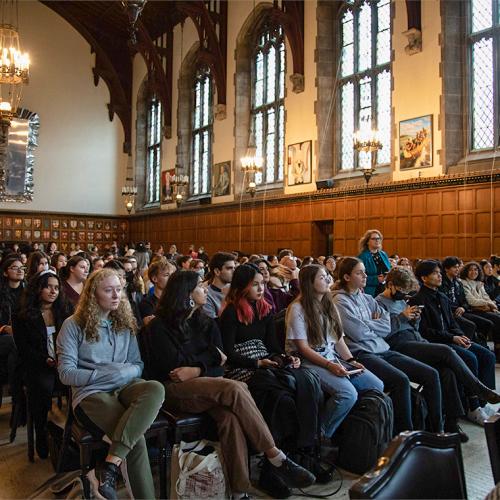 Every seat is taken in an audience of students filling Hart House Great Hall.