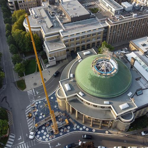 A tall crane stands next to Convocation Hall and its circular roof with a skylight in the centre.