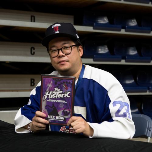 Alex Wong holding his book