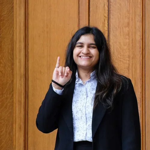 A portrait of Vishakha Pujari showing off her engineering ring on her pinkie finger