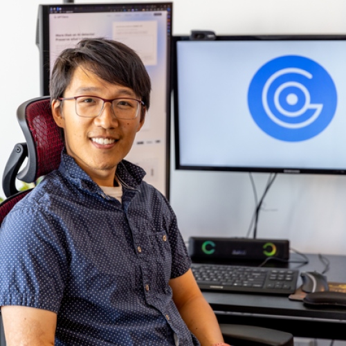 Alex Cui sitting in front of computer screens