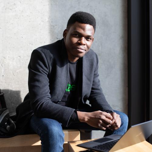 Olugbenga Olubanjo smiles as he looks up from the laptop he is working on.