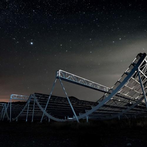 The CHIME radio telescope looks like giant cylinders made of metal scaffolding, cut in half, and lying on their sides.