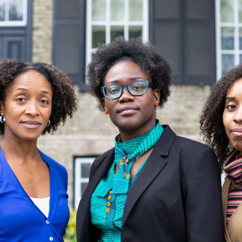Aisha Lofters, Onye Nnorom and Nakia Lee-Foon stand outside a building, looking thoughtful.